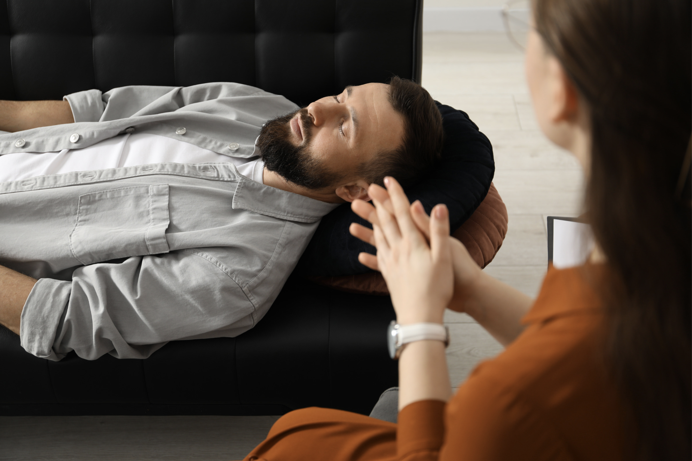 un homme allongé dans un canapé à ses côté une femme assise